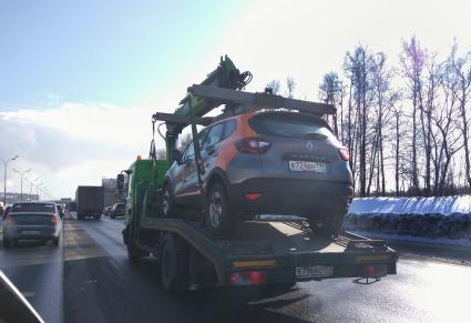 Москва.  Автомобиль каршеринговой системы `Делимобиль`  на эвакуаторе.