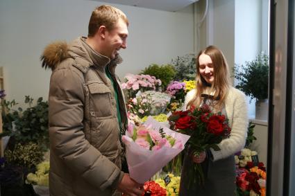 Красноярск.  Мужчина покупает цветы к празднику  8 марта.