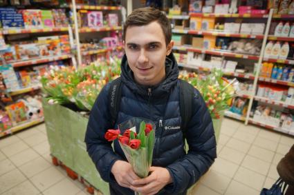 Самара. Юноша держит букет тюльпанов.