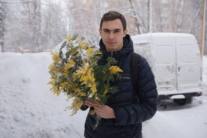 Самара. Молодой человек с букетом мимозы.