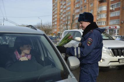 Тула. Сотрудник ДПС  поздравляет женщину-водителя в преддверии празднования Международного женского дня.