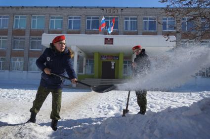 Самара.  Юнармейцы расчищают снег у здания школы.