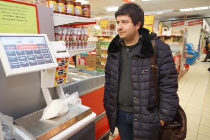 Самара.  Мужчина взвешивает товар в продуктовом магазине.