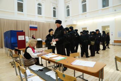 Екатеринбург. Сотрудники полиции голосуют на избирательном участке во время выборов президента России в 2018г