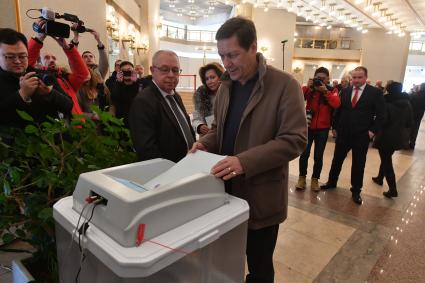 Москва.   Первый вице-спикер Госдумы РФ Александр Жуков (в центре) во время голосования на выборах президента РФ на избирательном участке #2151.