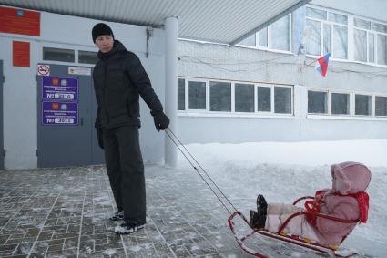 Самара. Мужчина с ребенком перед голосованием  на выборах президента РФ на избирательном участке #3011.