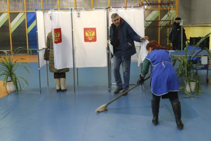 Алтайский край. Уборщица моет пол во время голосования на выборах президента РФ .