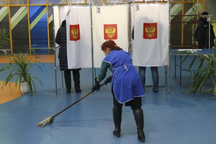 Алтайский край. Уборщица моет пол во время голосования на выборах президента РФ .