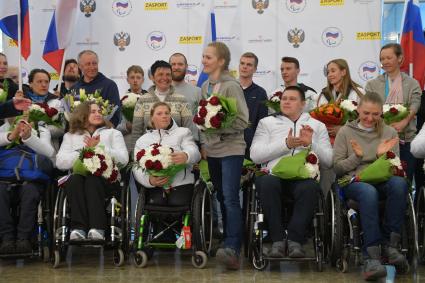 Москва.  Спортсменка Екатерина Румянцева  ( в центре) на церемонии встречи  российских спортсменов - участников  XI зимних Паралимпийских игр в аэропорту Шереметьево.