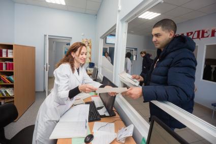 Челябинск.  Мужчина в регистратуре  детской поликлиники.