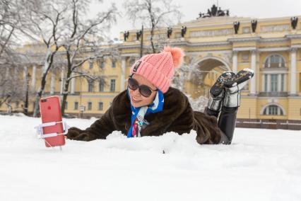 Санкт-Петербург. Китайские туристы делают селфи в снегу около памятника Петру I на Сенатской площади.