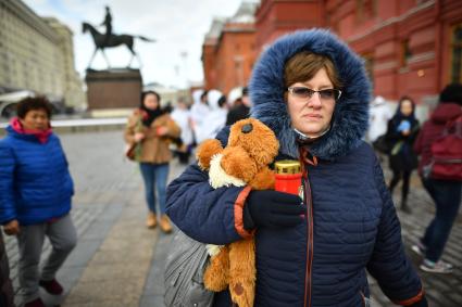 Москва.  Женщина идет к мемориалу на Манежной площади, организованному в память о погибших в ТЦ `Зимняя вишня`в Кемерово.