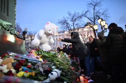 Москва. Горожане  несут цветы  и игрушки к памятнику  Пушкина  во время митинга   на Пушкинской площади, организованного в память о погибших  при пожаре в ТЦ `Зимняя вишня`в Кемерово.