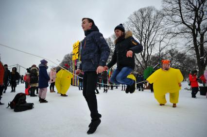 Москва.    Молодые люди  прыгают через скакалку во время  масленичных гуляний в  парке Горького.