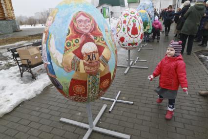 Барнаул. Девочка рядом с декоративным Пасхальным яйцом.
