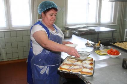 Нижний Новгород.  Повар во время приготовления на кухне   в школьной столовой.