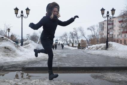 Самара. Девушка  перепрыгивает через лужу.