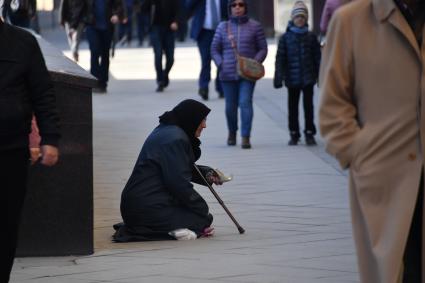 Москва. Женщина просит милостыню у прохожих на Тверской улице