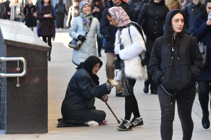 Москва. Женщина просит милостыню у прохожих на Тверской улице