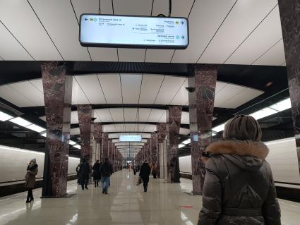 Москва. Женщина изучает табло с указателями движения на станции  метро.