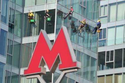 Москва.  Промышленные альпинисты моют окна  в доме  у метро Трубная.