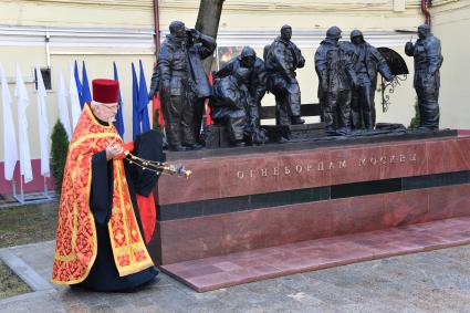 Москва. Священнослужитель во время церемонии открытия памятника `Огнеборцам Москвы` на территории исторического здания пожарного депо XIX века в день 100-летия советской пожарной охраны.