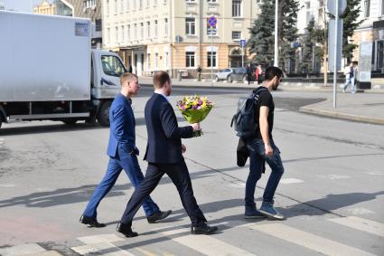 Москва. Мужчина с букетом цветов переходит улицу.