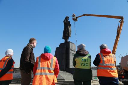 Красноярск.   Сотрудники коммунальных служб моют памятник  В.И. Ленину на одной из улиц города.