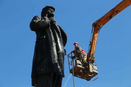 Красноярск.  Сотрудницы коммунальных служб моют памятник  В.И. Ленину на одной из улиц города.