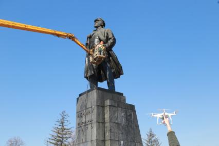 Красноярск.   Сотрудники коммунальных служб моют памятник  В.И. Ленину на одной из улиц города.