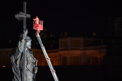 Москва.  Сотрудники  коммунальных служб моют памятник Владимиру Великому на Боровицкой площади.