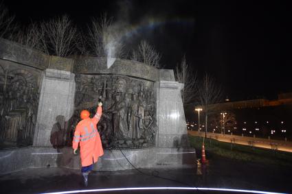 Москва.  Сотрудник  коммунальных служб моет памятник Владимиру Великому на Боровицкой площади.