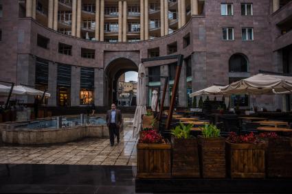 Ереван. Прохожие под зонтом на улицах города.