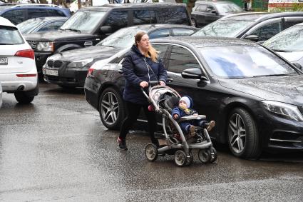 Москва.  Женщина с ребенком на одной из улиц города.