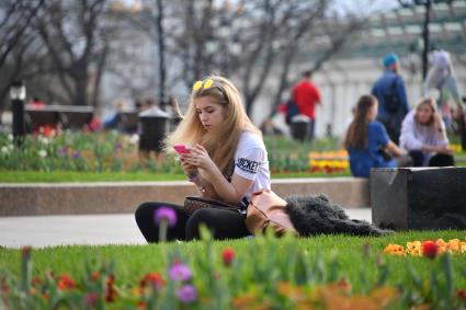 Москва.  Девушка с мобильным телефоном в Александровском саду.