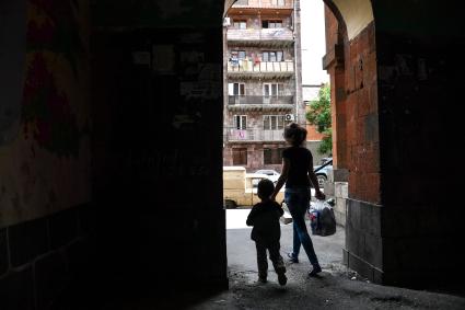 Армения, Ереван. Женщина с ребенком на улице старого и бедного района Конд.