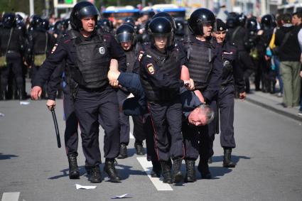 Москва. Сотрудники полиции и участник несогласованной протестной акции оппозиции Алексея Навального `Он нам не Царь`  на Пушкинской площади.