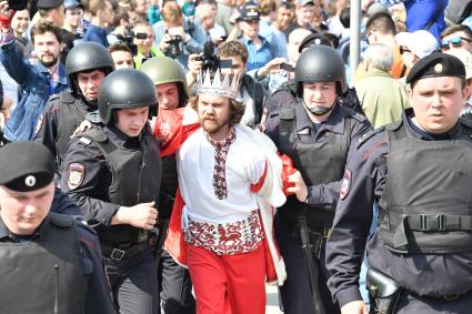 Москва. Сотрудники полиции и участник  несогласованной протестной акции оппозиции Алексея Навального `Он нам не Царь`  на Пушкинской площади.