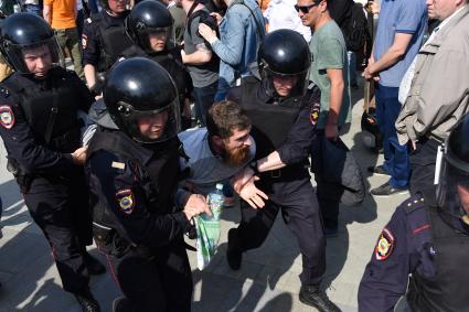 Москва. Сотрудники полиции и участник несогласованной протестной акции оппозиции Алексея Навального `Он нам не Царь`  на Пушкинской площади.