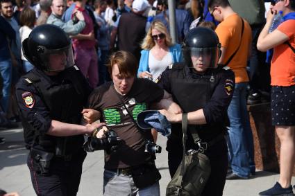 Москва. Сотрудники полиции и участник несогласованной протестной акции оппозиции Алексея Навального `Он нам не Царь`  на Пушкинской площади.