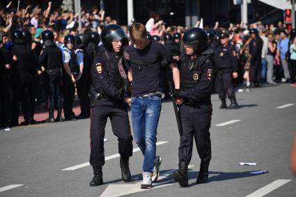 Москва. Сотрудники полиции и участник несогласованной протестной акции оппозиции Алексея Навального `Он нам не Царь`  на Пушкинской площади.