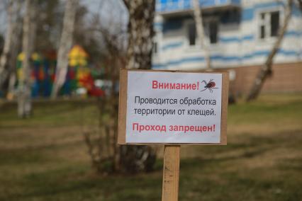 Красноярск. Табличка в парке `Проводится обработка территории от клещей`.