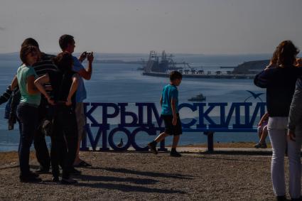 Республика Крым, Керчь. Туристы фотографируют вид на  Крымский мост и Керченский пролив.