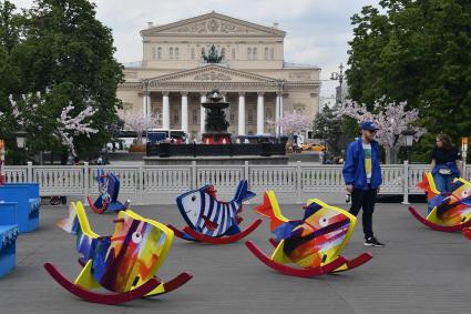 Москва. Качели для детей в виде рыбок на площади Революции, где проходит  фестиваль `Рыбная неделя`.