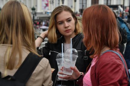 Москва. Девушки держат пластиковые стаканчики.