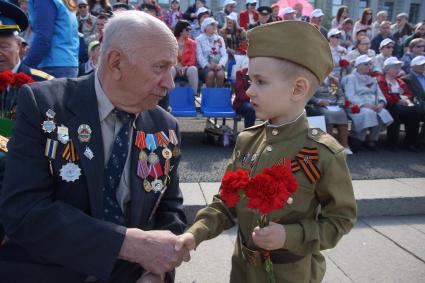 Самара. Мальчик поздравляет ветерана Великой Отечественной войны во время празднования Дня Победы.