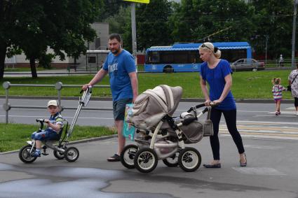 Москва.  Мужчина и женщина с детьми на одной из улиц города.