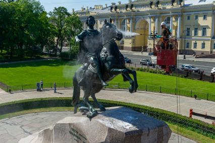 Санкт-Петербург. Работник музея Городской скульптуры моет памятник Петру I `Медный всадник` на Сенатской площади.