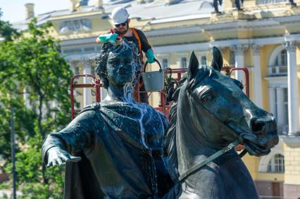 Санкт-Петербург. Работник музея Городской скульптуры моет памятник Петру I `Медный всадник` на Сенатской площади.