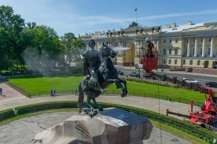 Санкт-Петербург. Работник музея Городской скульптуры моет памятник Петру I `Медный всадник` на Сенатской площади.